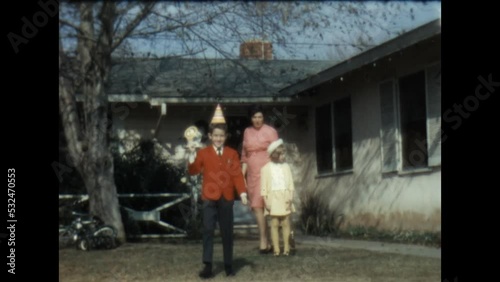 Boy in a Birthday Hat 1967 - A boy wears a birthday hat while his mother and sister look on, in Canoga Park, California in 1967. 