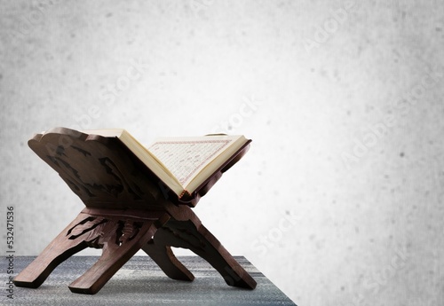 Quran on wooden stand with gray background. Islamic concept.