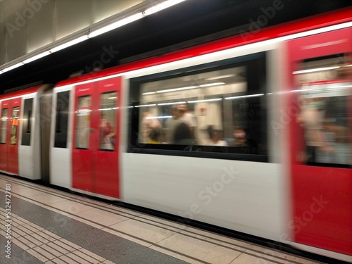 Wide angle view of an electric train accelerating with motion blur in a metro station in Barcelona, ​​Spain. Travel and public transport concept.