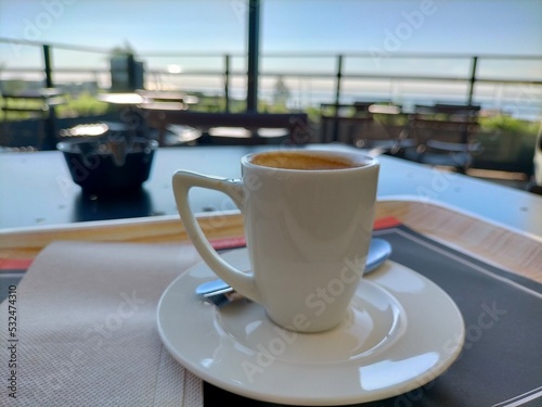 cup of coffee in a rooftop cafe, open terrace with metal tables photo