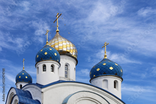 Fotobehang Eastern orthodox crosses on gold and blue domes or cupolas againts blue sky with clouds