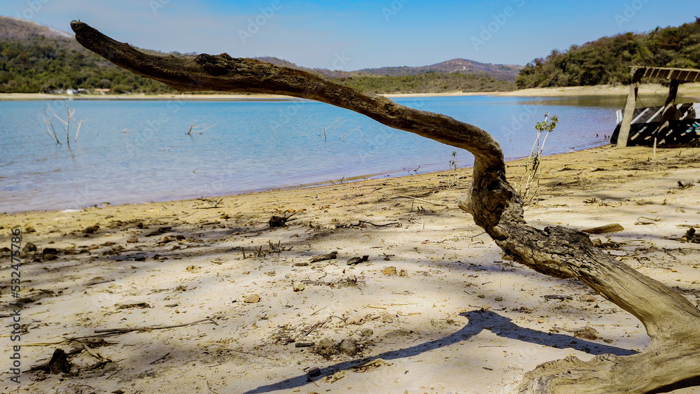 Lindo manhã, com céu dourado e limpo, e pequeno tronco na praia de água doce da represa da Várzea das Flores, em Contagem, Minas Gerais, Brasil. Lindo manhã, com céu dourado e limpo, e pequeno tronco na praia de água doce da represa da Várzea das Flores, em Contagem, Minas Gerais, Brasil.