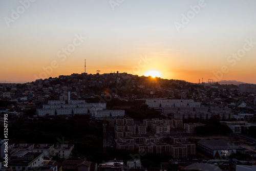 Lindo pôr do sol ao entardecer com céu laranjado limpo, em pedreira no bairro Industrial, Contagem, Minas Gerais.