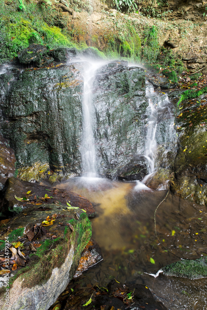 Fototapeta premium Pequena nascente, com águas cristalinas, muitas rochas ao redor em meio a mata de zona rural, no bairro Jardim das Oliveiras, Esmeraldas, Minas Gerais, Brasil.