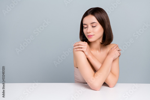 Photo of lady touch hands shoulders cuddle herself protect chest sit podium isolated over grey color background