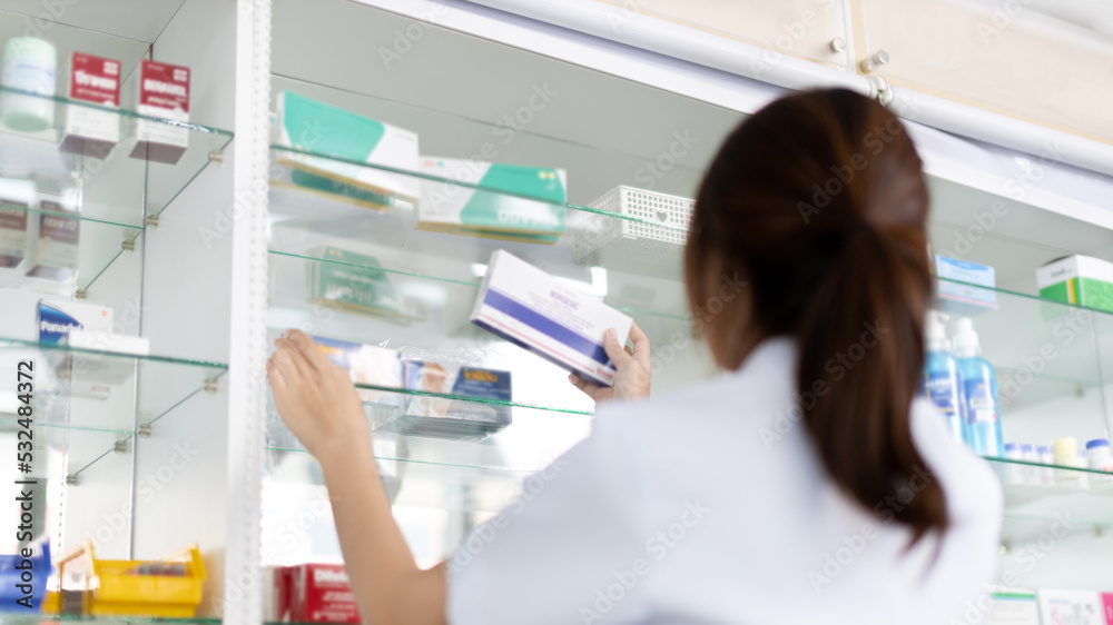 Pharmacist picks up pills on shelf from doctor's prescription, All kinds of generic household drugs and pharmaceutical products on the shelf , Administering medications as prescribed by the doctor.