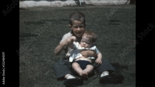 Waving with Brother 1965 - A boy helps his baby brother wave for the camera in Canoga Park, California in 1965. photo