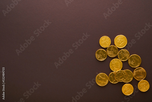 Chocolate coin. Backgrounds of chocolate Euro coin money on brown background. Euro coins stacked on each other in different positions. Group of coins. Mock up.