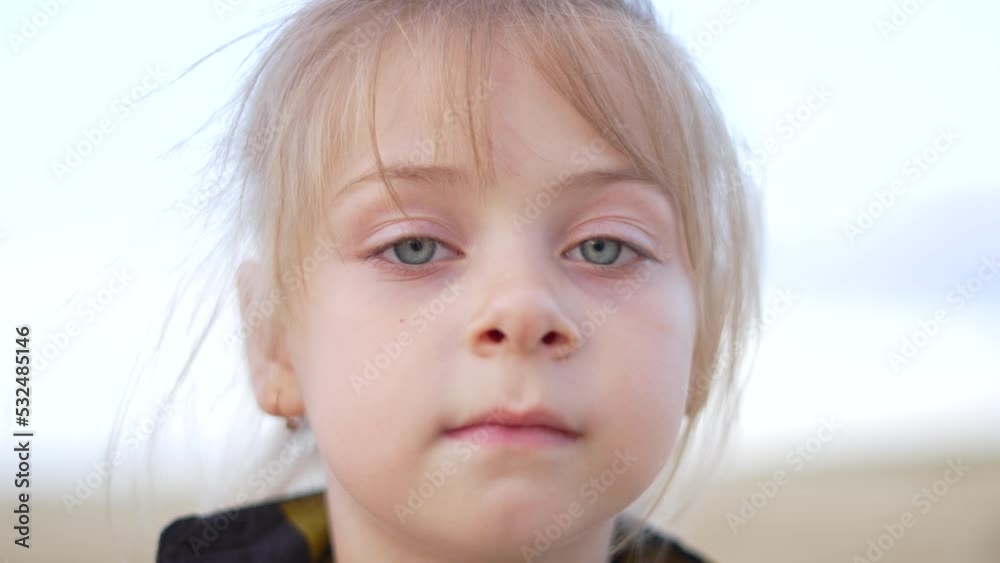 Portrait of baby girl face. Happy healthy face of girl. Blond hair in wind. Stubborn look of beautiful eyes.Baby kid in nature.Portrait of daughter cute eyes.Girl look portrait of child face at sunset Portrait of baby girl face. Happy healthy face of girl. Blond hair in wind. Stubborn look of beautiful eyes.Baby kid in nature.Portrait of daughter cute eyes.Girl look portrait of child face at sunset