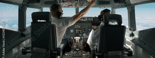 Slika na platnu Commercial aircraft pilots adjusting flight parameters of the plane during the flight at high altitude