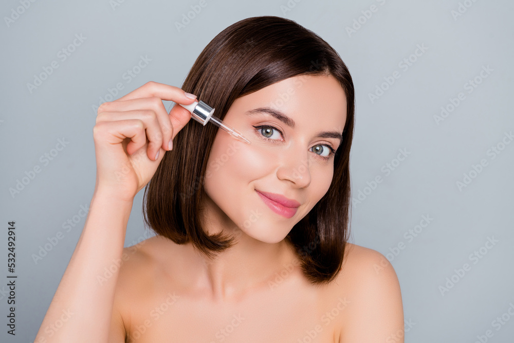 Portrait of girlish gentle lady use serum oil rejuvenating face skin aesthetic treatment isolated on grey color background Portrait of girlish gentle lady use serum oil rejuvenating face skin aesthetic treatment isolated on grey color background