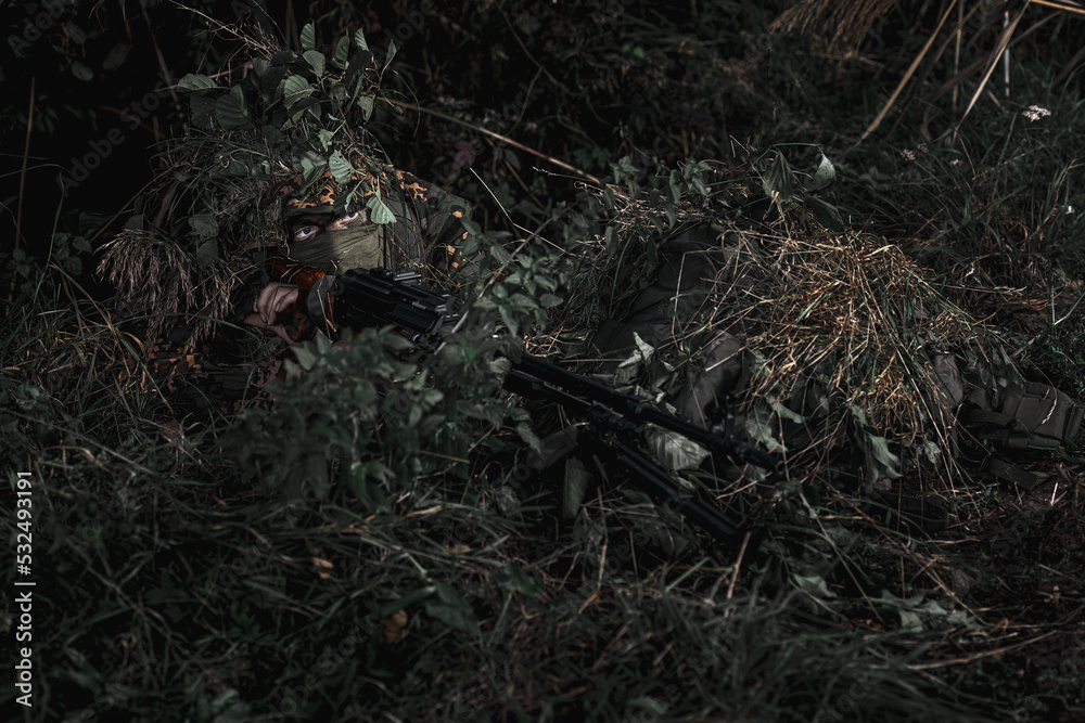 Obraz premium Eastern special forces soldier with rifle in woodland