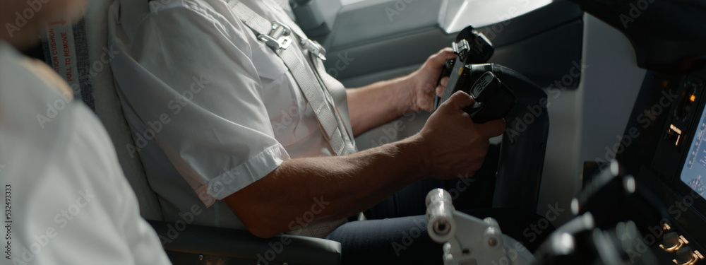 CU Commercial aircraft pilots adjusting flight parameters of the plane during the flight at high altitude. View from inside the cabin. Real aircraft, daytime shot