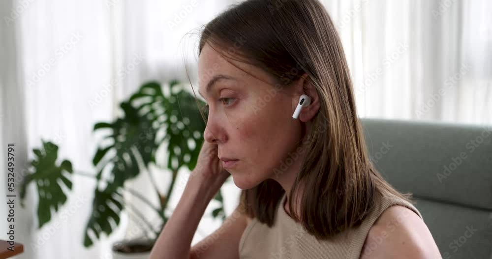 Close up female put on white modern wireless earphone in ear and turn on sound hear music, play favourite song, listen audio voice message, start work out with popular track. Technology concept Close up female put on white modern wireless earphone in ear and turn on sound hear music, play favourite song, listen audio voice message, start work out with popular track. Technology concept
