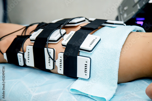 In a beauty salon, a girl performs a hardware procedure for weight loss laser lipolysis. Figure correction by hardware methods