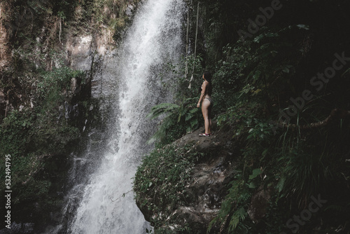 girl in swimsuit looking at kaiate waterfall photo