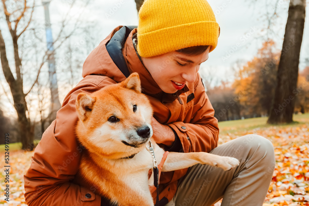 Family lovingly hugging dog. Sincere friendship with pet. Owners walk the dog in the park and patting it . Akita Inu breed. Mental health and stress relieve by pet. People hug dog