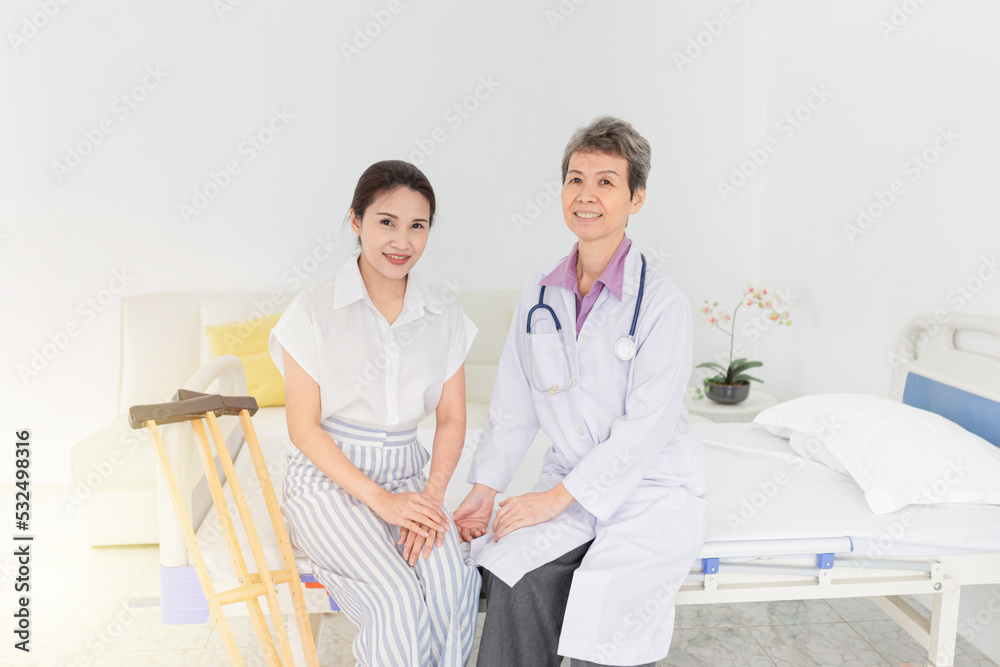 Obraz premium asian patient learning to use crutches with doctor, she training and rehabilitation, doctor assessment of patient leg