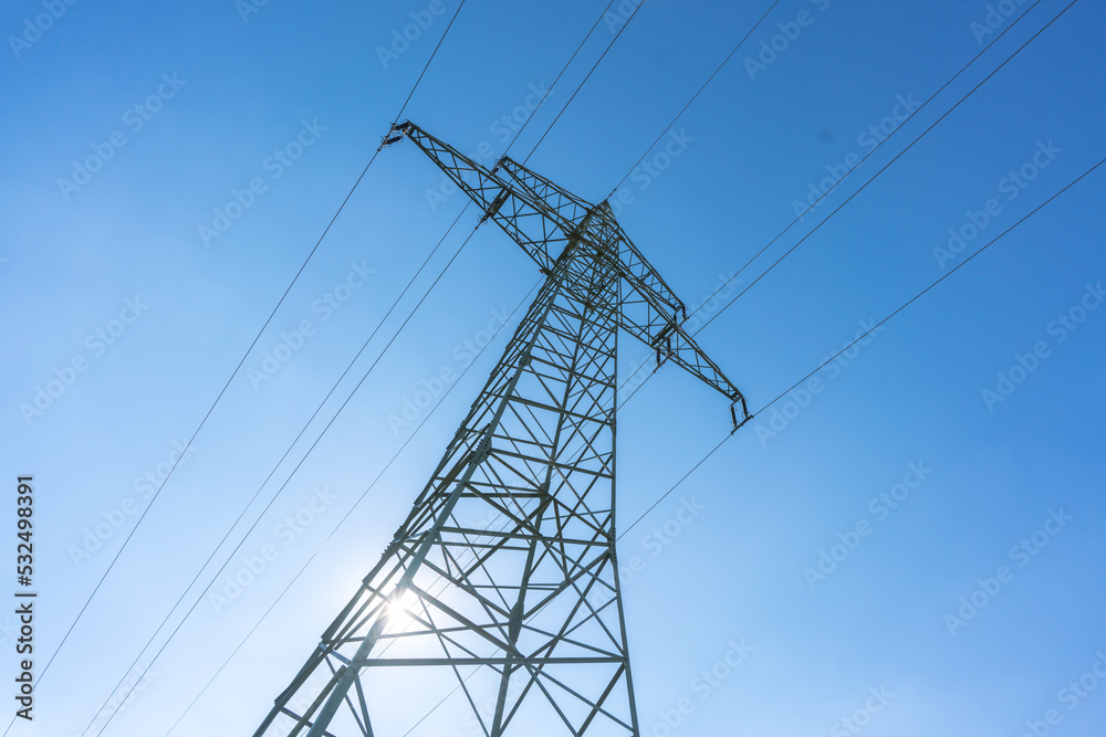 Electricity pylon for over land power transmission of high voltage in front of blue sky Electricity pylon for over land power transmission of high voltage in front of blue sky