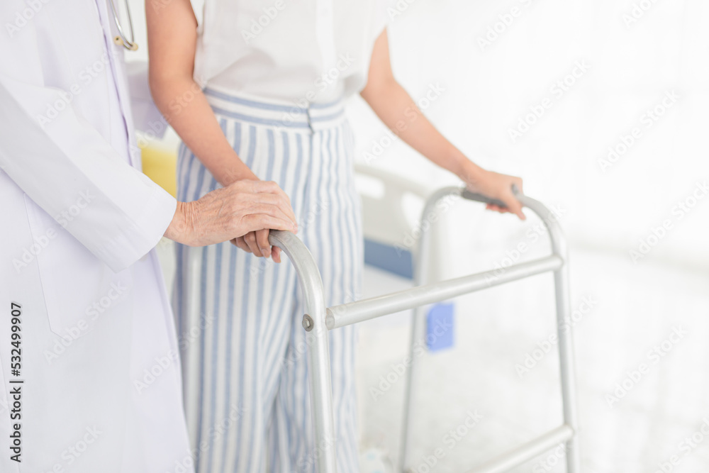 Fototapeta premium female patient train to use walker with doctor, walk training and rehabilitation process 