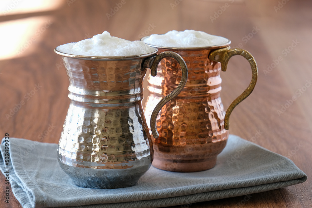 Buttermilk, Ayran Traditional Turkish yoghurt drink with foam in a copper metal cup. Sparkling