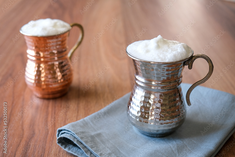 Buttermilk, Ayran Traditional Turkish yoghurt drink with foam in a copper metal cup. Sparkling