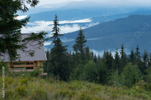 house in the mountain forest with a view of the mountains covered by low clouds 