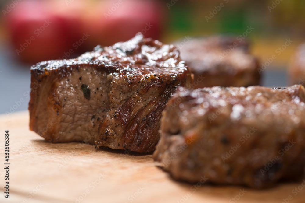 Closeup of grilled meat chunks served on wooden board Closeup of grilled meat chunks served on wooden board