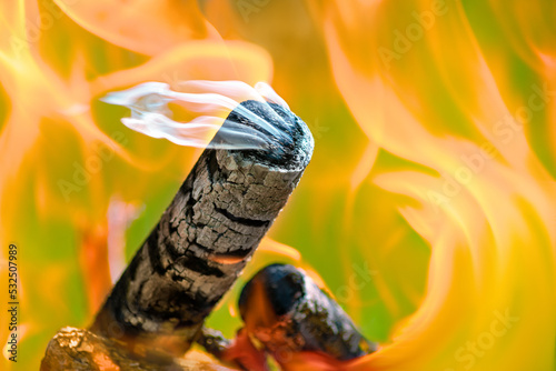 Burning firewood on a green and orange background