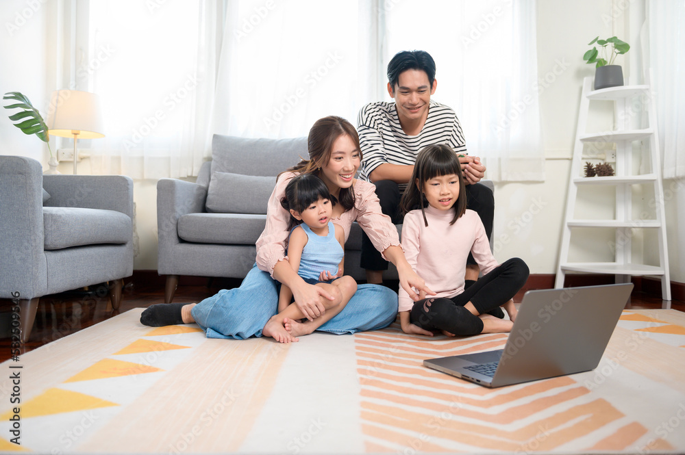 Asian family with children using laptop computer at home Asian family with children using laptop computer at home