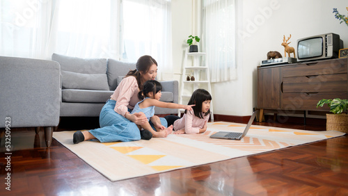 Asian family with children using laptop computer at home