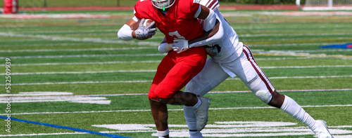 Foto Football receiver trying to escape a tackle after catching the ball during a gam