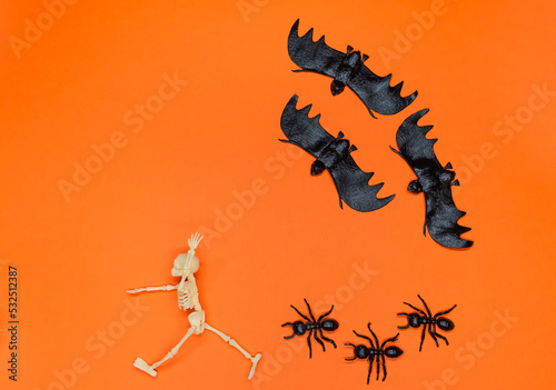 Skeleton running away from bats and ants. A running skeleton. Halloween party. Day of the Dead