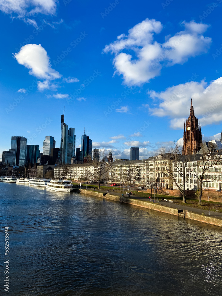 View of the business corporate downtown bank district with high tall skyscraper buildings, Saint Bartholomeus's Cathedral, and Eiserner Steg bridge over the Main River in Frankfurt am Main, Germany.