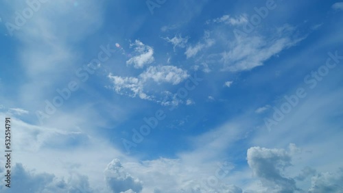 Beautiful cirrus and cumulus clouds visible in blue sky. Translucent cirrus spindrift clouds high up. Timelapse.