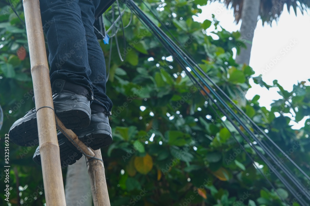 Obraz premium A worker trying to solve the electrical wires problem at Thailand