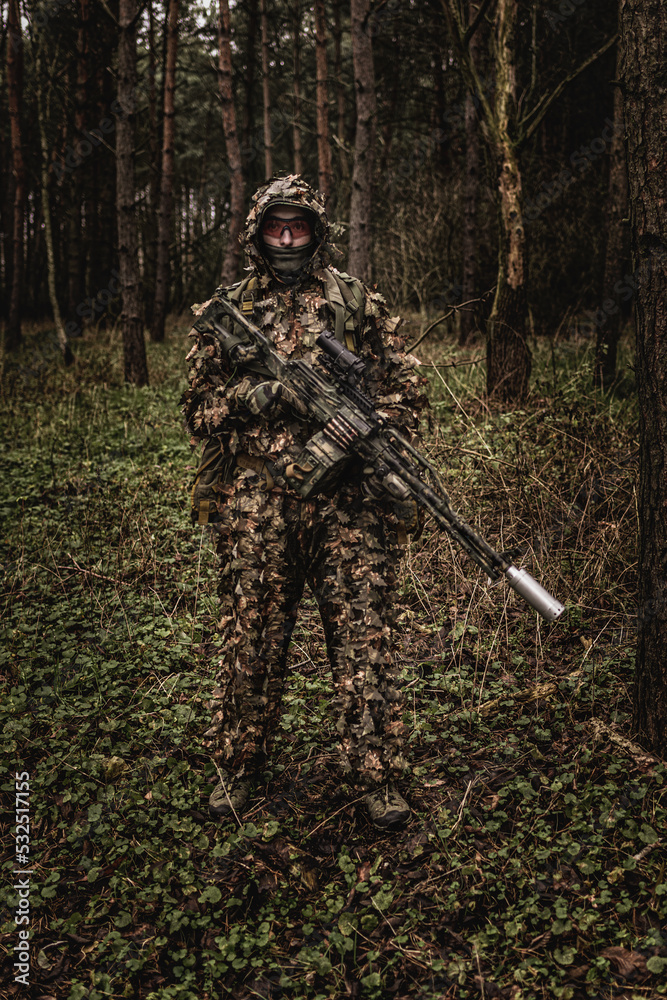 Eastern special forces soldier with rifle in woodland during autumn ...