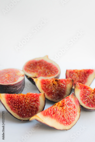 Photo of a fig close-up on a white background. Ripe fruit whole and in pieces.