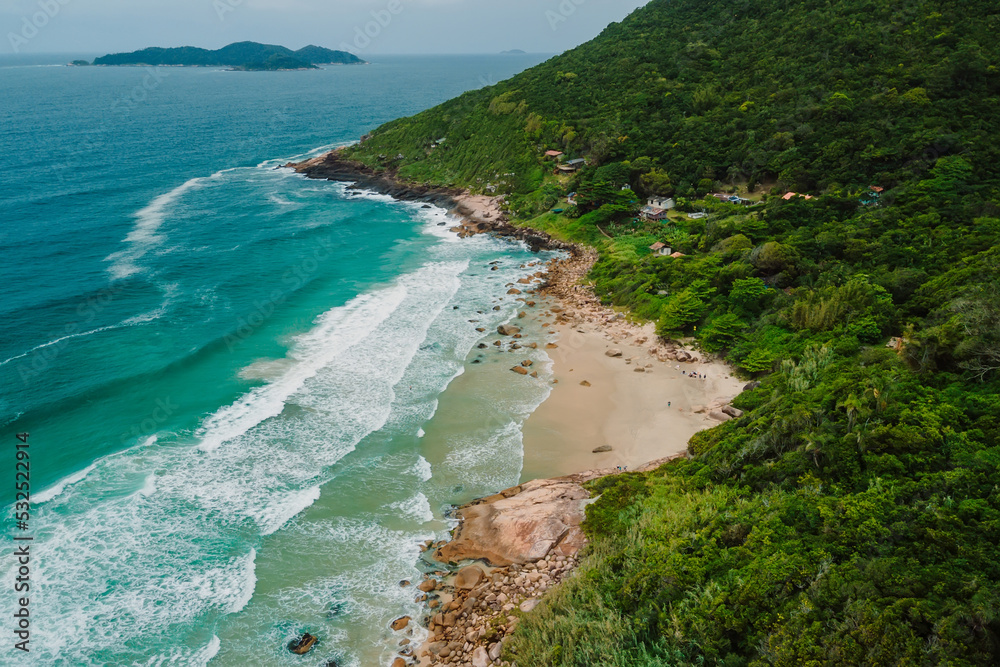 Coastline with beach, mountains and ocean with waves in Brazil. Aerial view of Saquinho beach