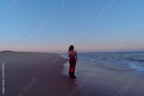 Woman Walking Shoreline At Sunset photo