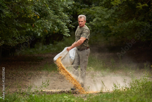 Game ranger spreading maize for animals
