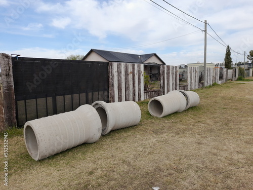 Konstfotografi Tubos o caños de hormigòn prefabricados en fila sobre el cèsped para conducir ag