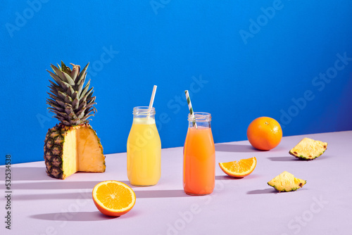 two tasty healthy orange drink fruits juice bottles on color photo