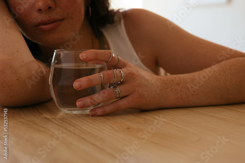 Freckled teen girl with glass of water