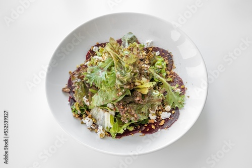 Beets Goat Cheese Salad served in a dish isolated on grey background top view