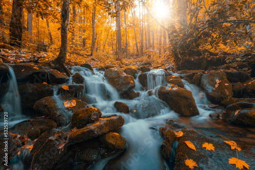 A Tennessee waterfall is illuminated by romantic sunlight during autumn in the Smoky Mountains.