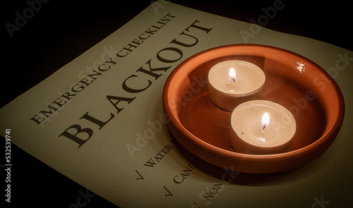 two tea lights in a terracotta coaster on a blackout emergency checklist during a power outage