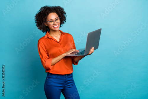 Portrait of beautiful trendy cheery wavy-haired girl using laptop study education isolated on vivid blue color background photo