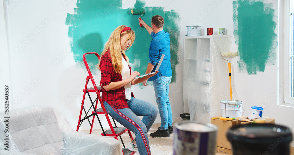Φωτογραφία Caucasian happy young couple male and female renewing apartment changing room color