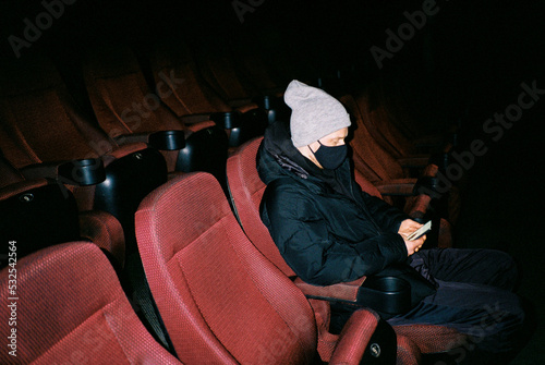 Young man in mask in cinema photo